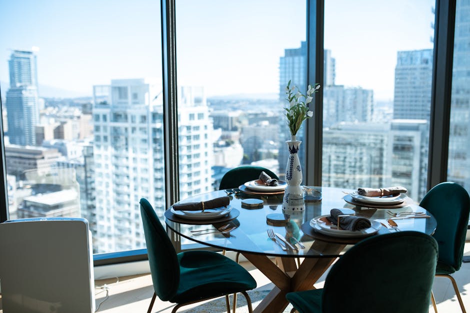 Elegant dining table set against a stunning urban cityscape view, perfect for upscale lifestyle settings.
