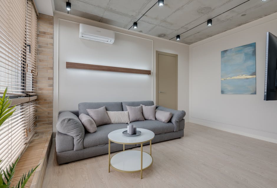 Stylish living room with a gray sofa, abstract art, and minimalist design.