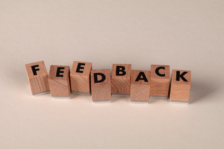 Wooden letter blocks arranged to spell 'FEEDBACK' on a neutral background. Ideal for communication concepts.