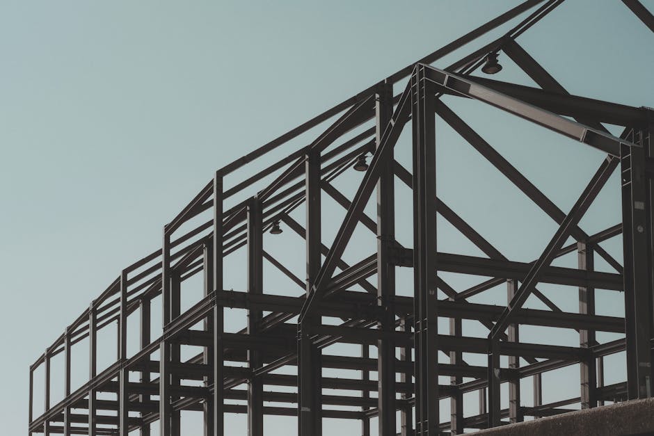 Modern steel framework structure under clear sky, showcasing architectural design.